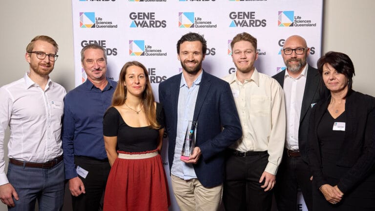 A group of DMC employees smiling together for an official photograph at the award ceremony